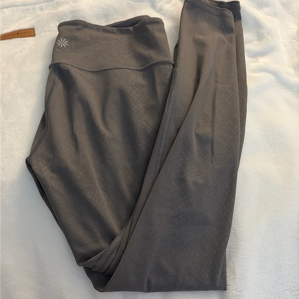 Athletic leggings, grayish, purple, snake print pattern.